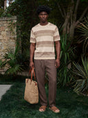 Man wearing the VAËL Solário striped knit T-shirt in earth tones