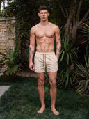 Man wearing the VAËL Lucéro swim shorts in terracotta