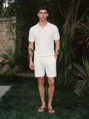 Man wearing the VAËL Aurélio open-collar knit polo in white