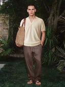 Man wearing the VAËL Marbella open-collar knit polo in warm ivory