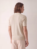 Man wearing the VAËL Marbella open-collar knit polo in warm ivory