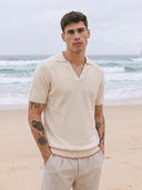 Man wearing the VAËL Marbella open-collar knit polo in warm ivory